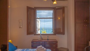 A bedroom with a bed, a dresser, a window with a view, and a wardrobe. - Gorgeous Villa with outbuilding for a relaxing vacation (Torre Colonna-Sperone)