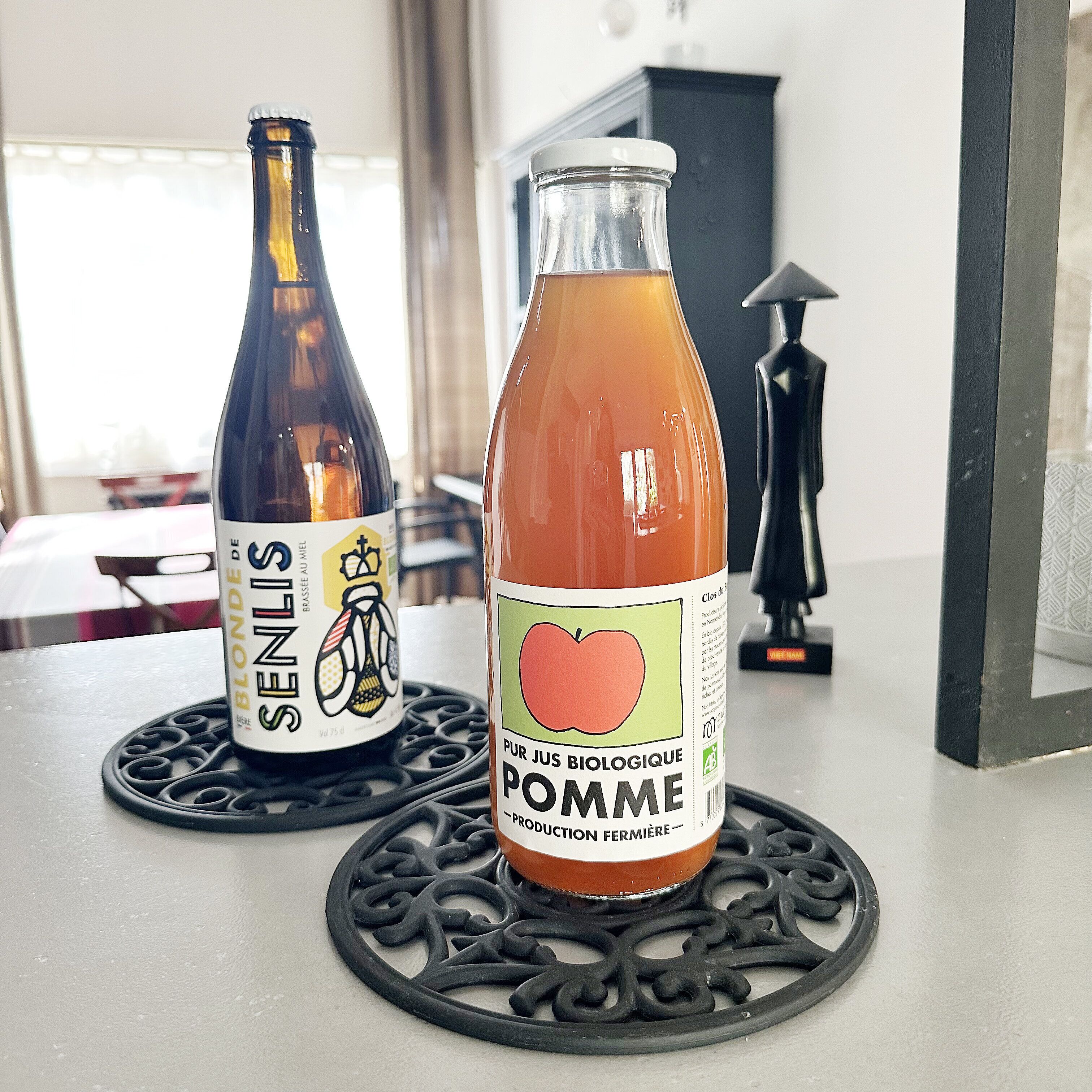 Två flaskor står på ett bord tillsammans med en dekorativ underlägg.