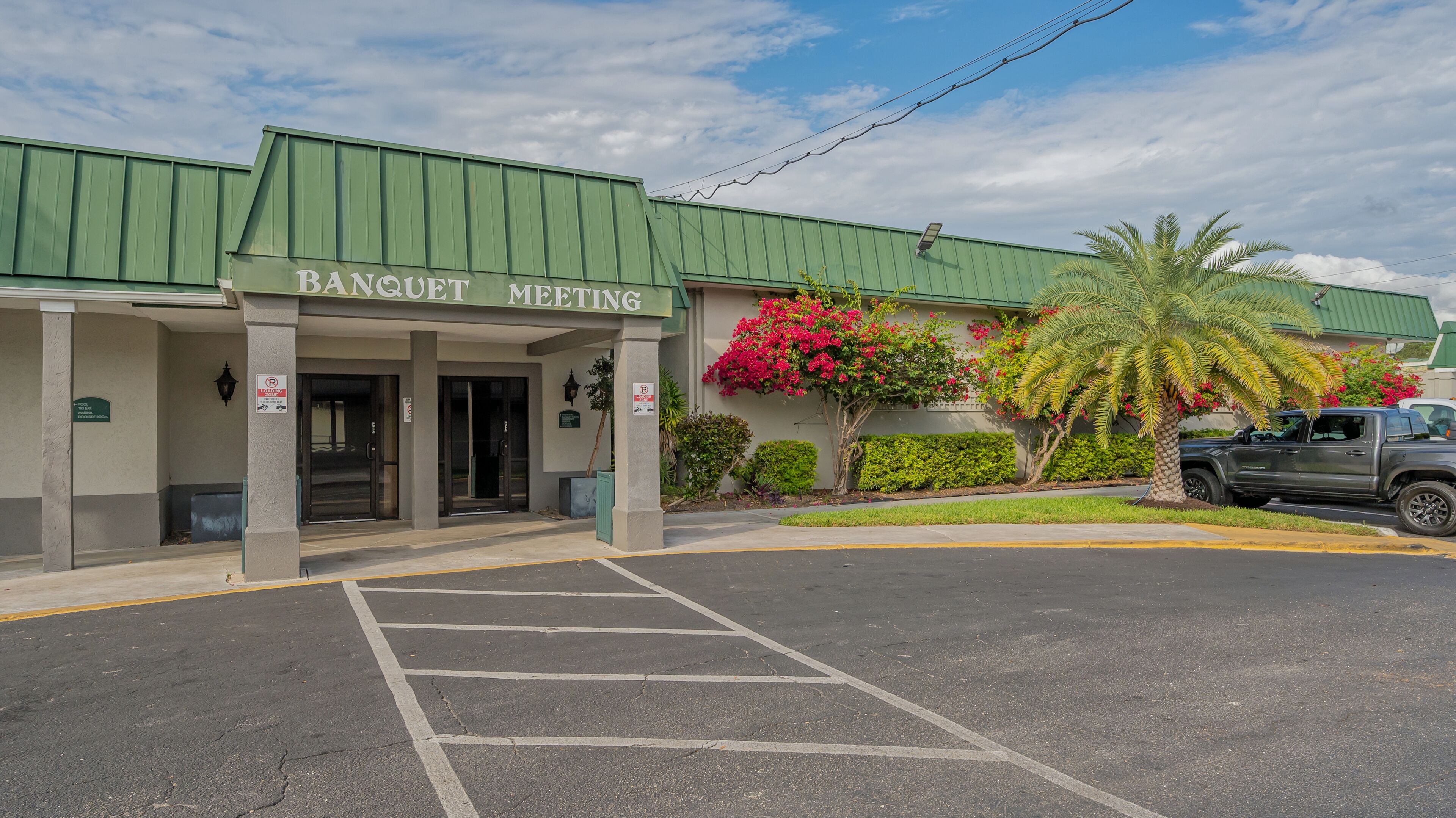 Un edificio con techo verde y un cartel que dice "BANQUET MEETING".