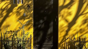 A yellow building with a black door, a number '9' sign, and a security keypad. - Discover Condesa (Mexico City)