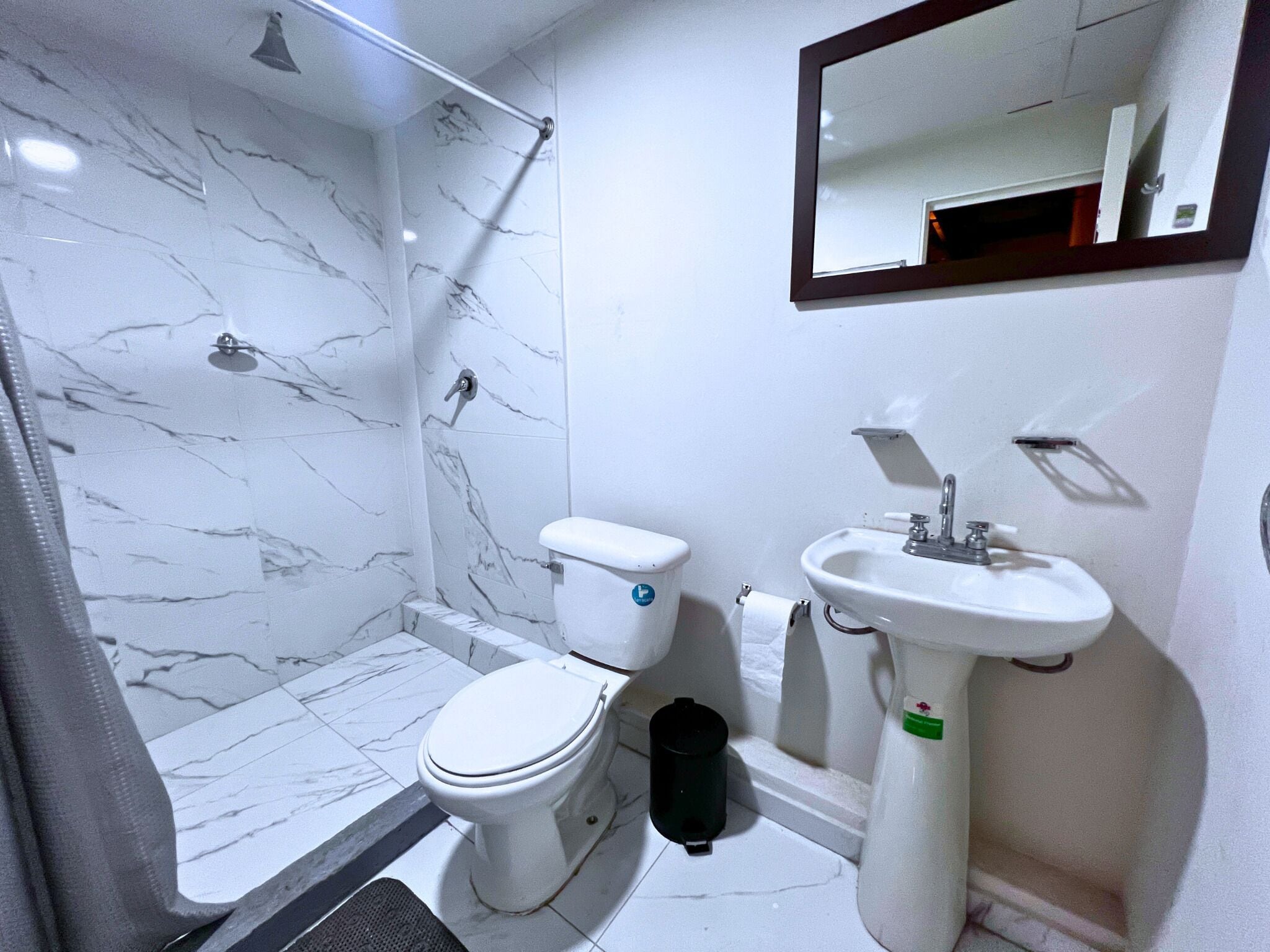 Un baño con inodoro, lavamanos y ducha.