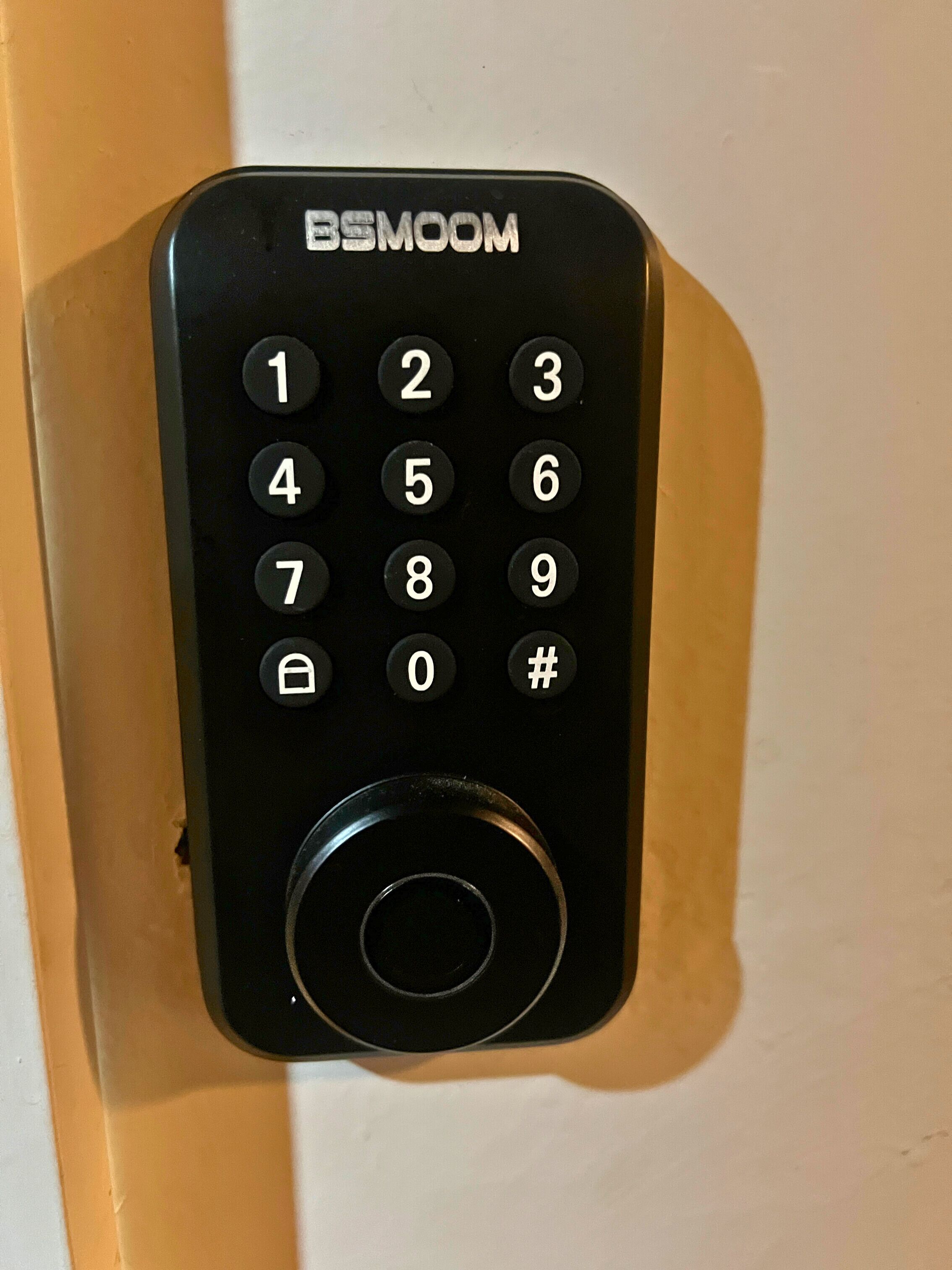 Een zwart BSMOO deur slot met een numeriek keypad en een rond sleutelgat.