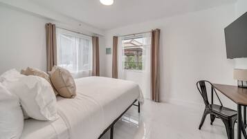 Une chambre à coucher avec un lit, un bureau et une chaise.