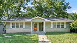 A single-story house with a front porch, a garage, and a well-maintained lawn. - Family Friendly 3 BR 2 Bath Duplex Sleeps 9! (Des Moines)