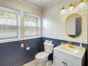 Une salle de bain avec des toilettes, un lavabo et un miroir.