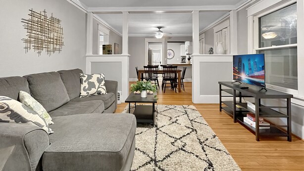 A modern living room with a grey sofa, a coffee table, and a TV on a stand.