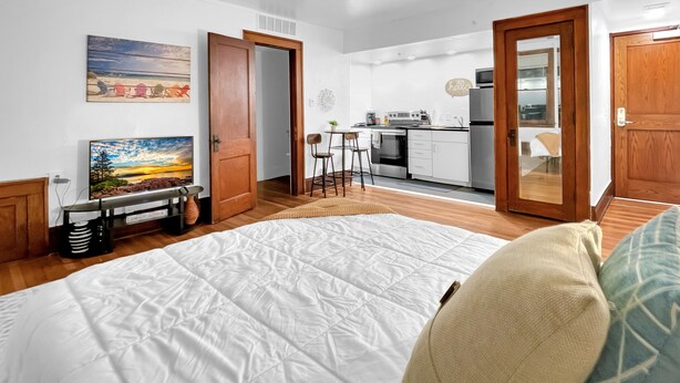 Een modern appartement met een groot bed, een keuken en een eethoek.