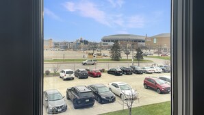 A parking lot with various cars, a large building with a dome, and a clear sky. - Stay in the heart of downtown! Walk to Casey's Center, restaurants, and nightlife. Enjoy free parking and all the comforts of home. (Des Moines)
