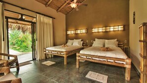 Habitación con dos camas, ventilador de techo y vistas al exterior.