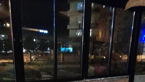 A round wooden table with six chairs, each with a dark cushion. The setting appears to be indoors with large windows in the background. - ATAKUM AYKA OTEL (Atakum)