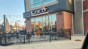 A restaurant named "Loco" with outdoor seating and a brick facade. - Minutes from downtown, the fairgrounds and the Speedway! Great Neighborhood! (Indianapolis)