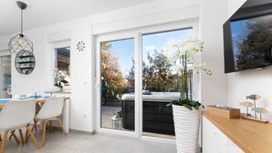 Eine moderne Küche mit großem Fenster, einem Einbauofen und einer weißen Spüle.
