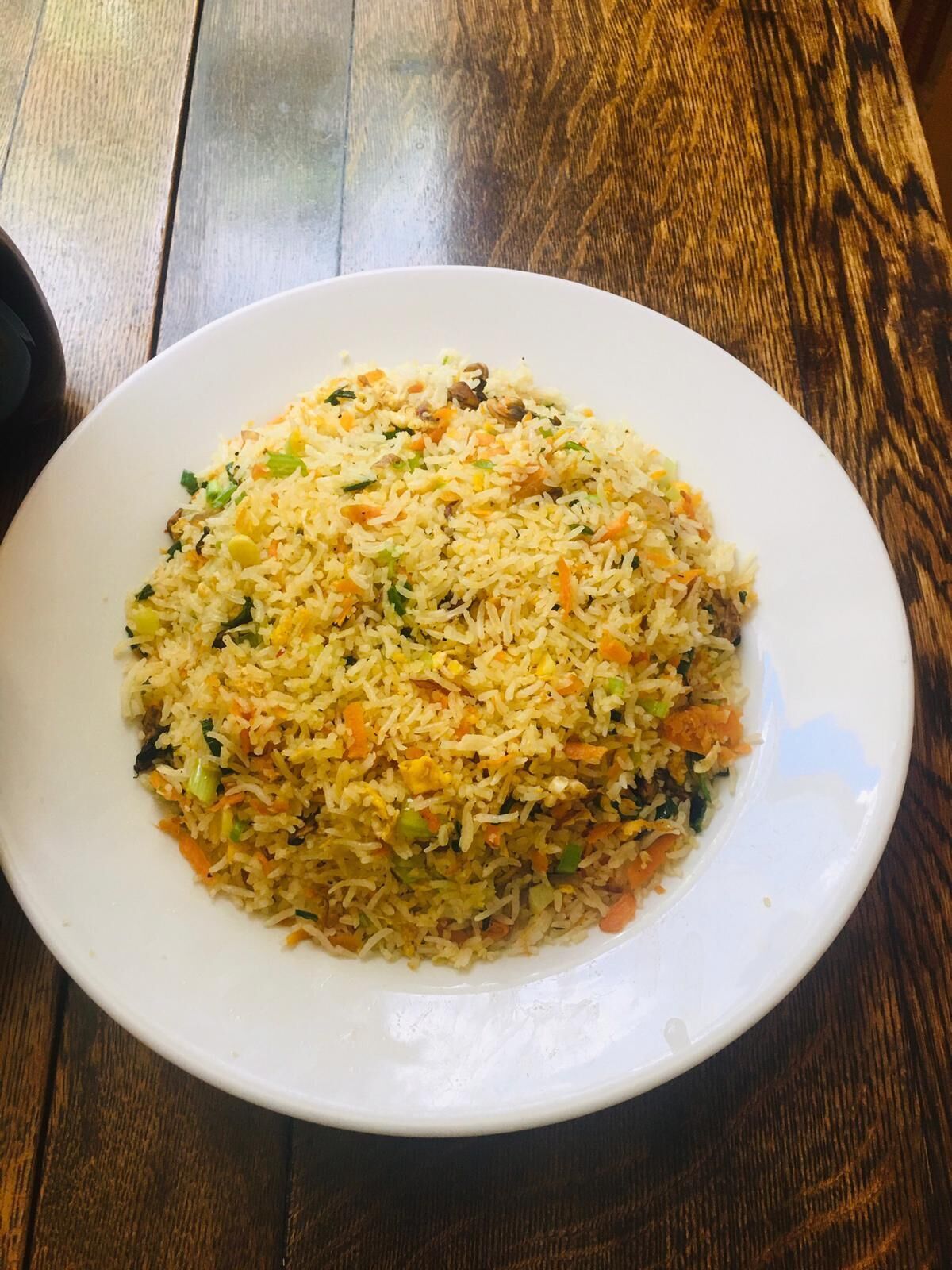 A plate of fried rice on a white plate.