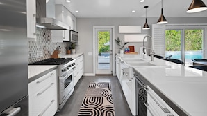 A modern kitchen with white cabinetry, stainless steel appliances, and pendant lighting. - 'Miles Away' A Desert Oasis - Palm Springs Style! (Palm Springs)