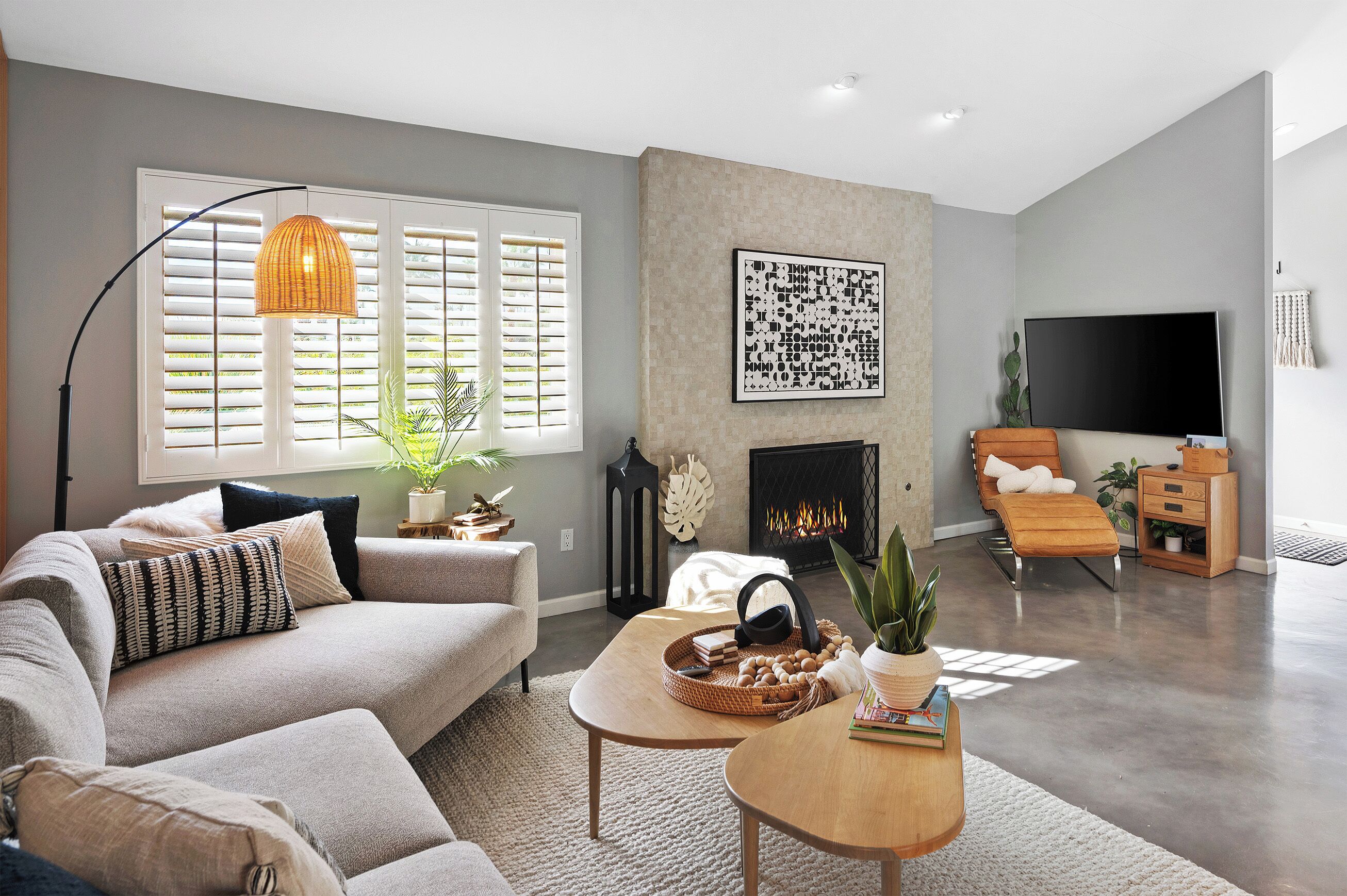 Een moderne woonkamer met een bank, salontafel en open haard.