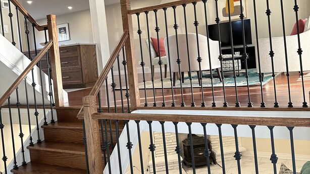 A spacious living area with a wooden staircase, a green sofa, and a coffee table.