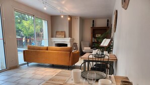 A cozy living room with a sofa, a dining table set with plates, glasses, and a coffee table.