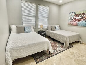 Ein Schlafzimmer mit zwei Betten, einem Teppich und einem Bild an der Wand.