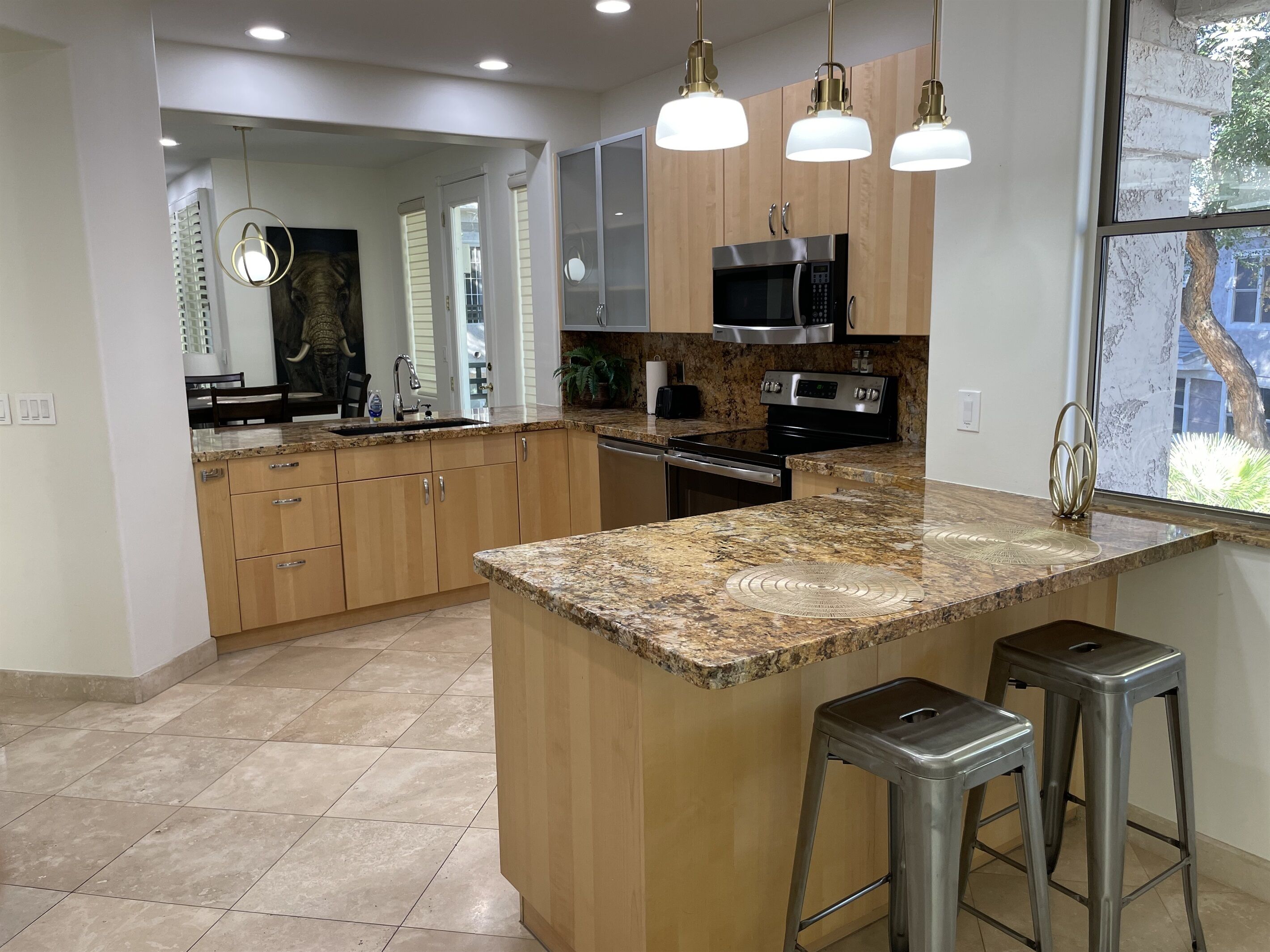 A modern kitchen with granite countertops, stainless steel appliances, and wooden cabinets.
