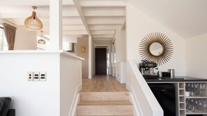 Eine moderne Küche mit einem integrierten Kühlschrank, einer Kaffeemaschine und einem Weinkühler.