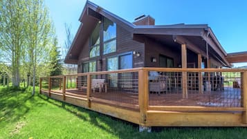 A modern two-story house with a large deck and a covered outdoor area.
