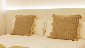 Ein Bett mit zwei Kissen und einem gefalteten weißen Handtuch.