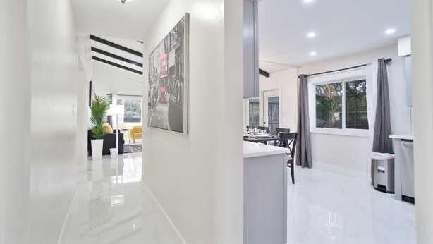 A modern kitchen with a large window, a sink, and a countertop.