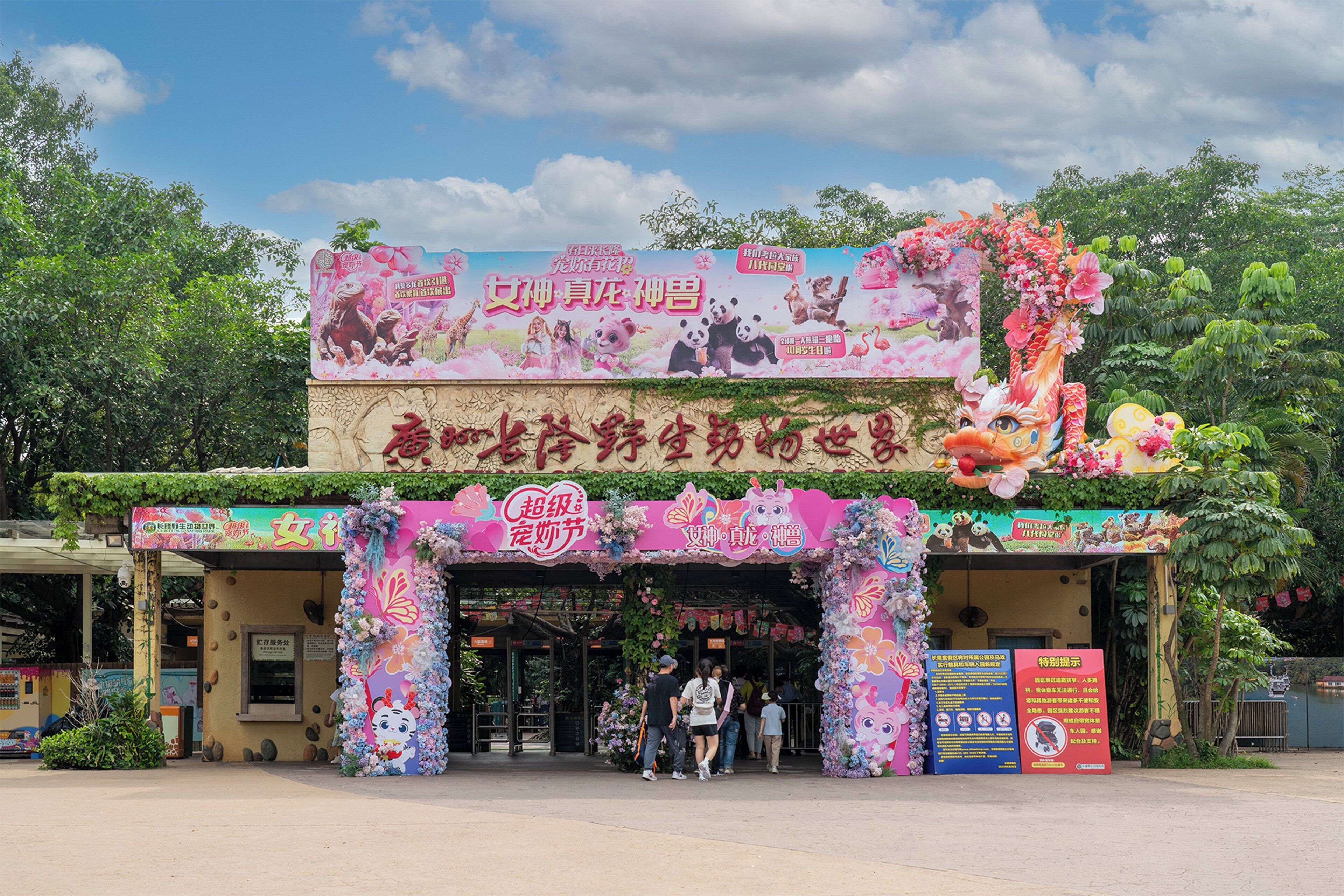 A colorful entrance with floral decorations and a signboard.