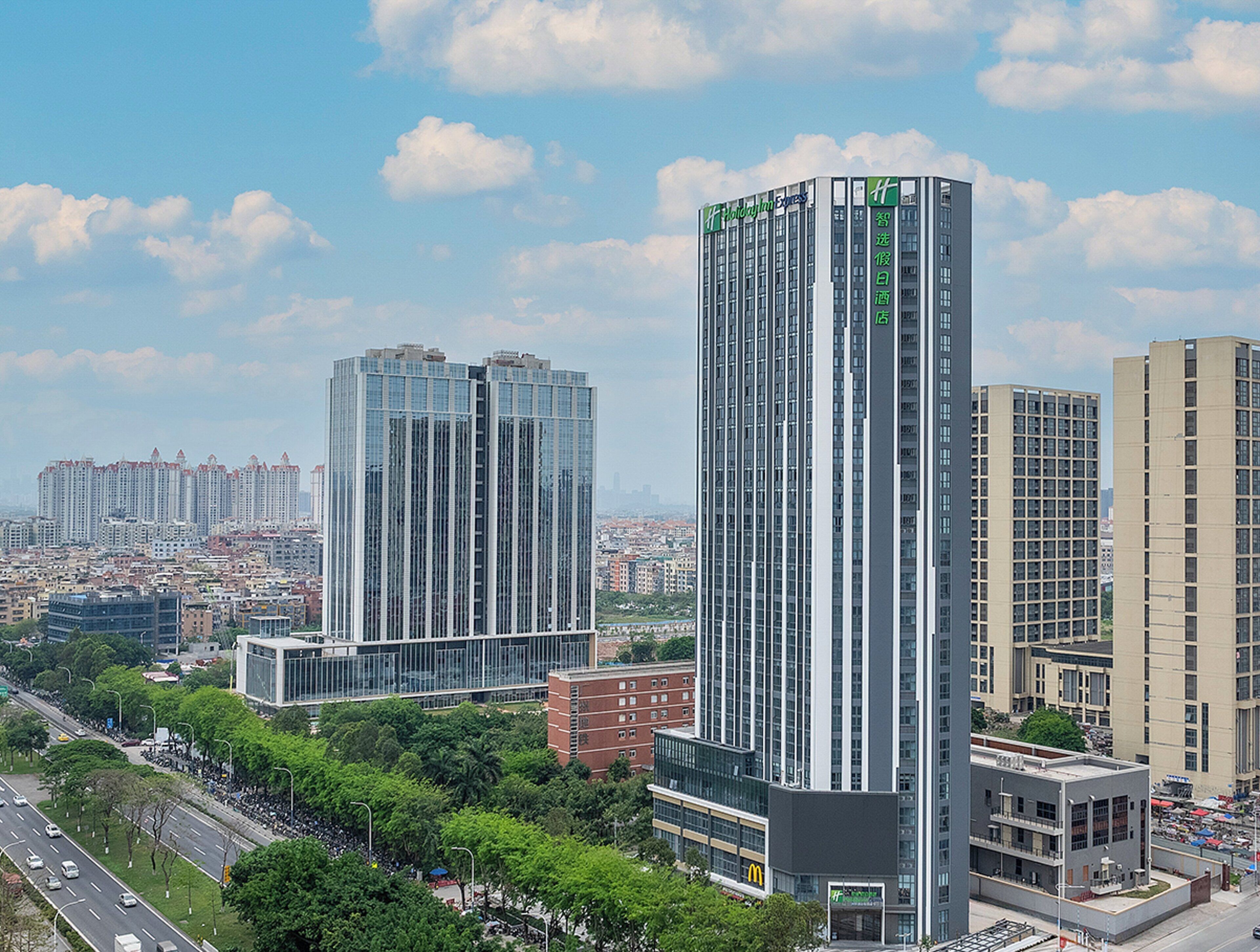 A high-rise hotel with a modern design, featuring multiple floors and a prominent logo on the facade.