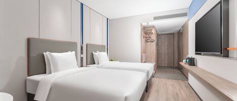 A modern hotel room with two beds, a large window, and a flat-screen TV.