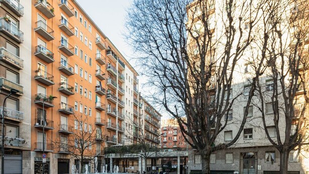 Une cour avec une fontaine, entourée d’immeubles résidentiels à plusieurs étages dotés de balcons.