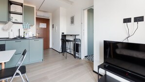 Une cuisine moderne avec un coin repas, un téléviseur et un petit bar.