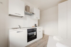 A modern kitchen with a built-in oven, a sink, and a stove. - GuestHost - Functional and modern 19 sqm studio, ideal for 2 people, located on the fourth floor of a building without lift. The accommodation is situated few steps away from the Maciachini MM, in a dynamic and well-serviced neighborhood of Milan. Perfec (Milano)