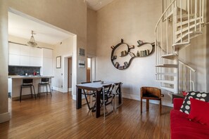 Un intérieur moderne comprenant un coin repas, une cuisine et un escalier.