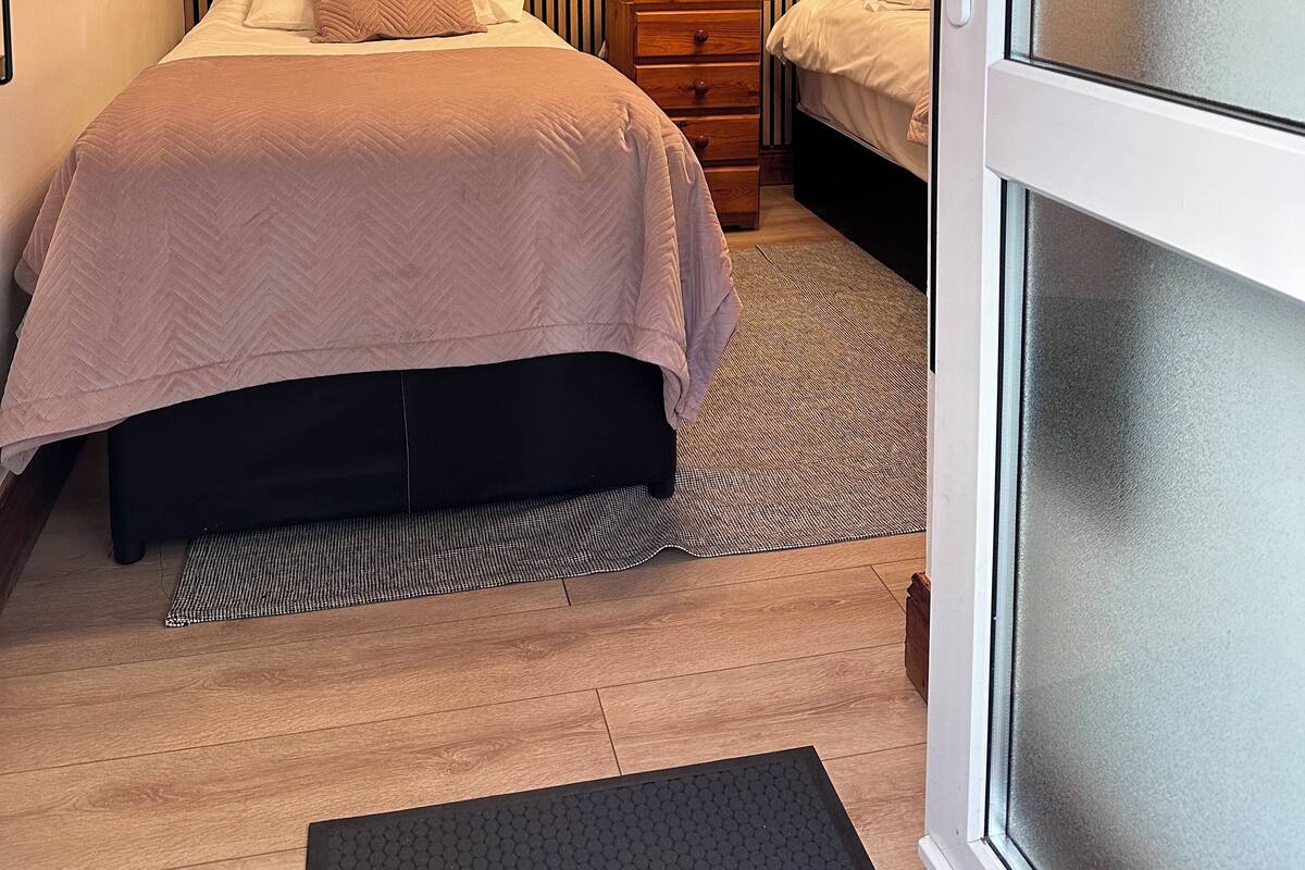 A bedroom with a bed, bedside tables, a lamp, and a window.