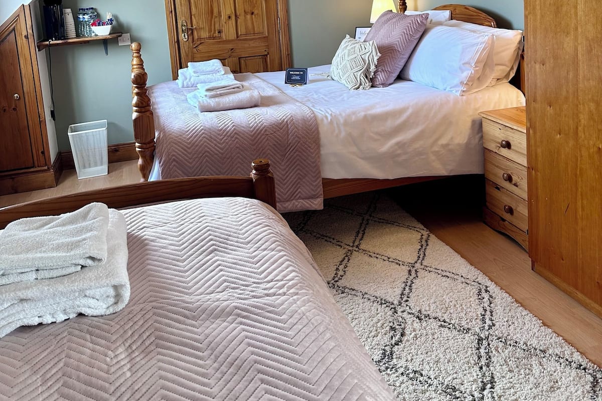 Traditionele driepersoonskamer, en-suite badkamer | 1 slaapkamer, een strijkplank/strijkijzer, beddengoed