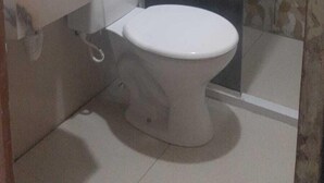 Un baño pequeño con inodoro, lavamanos y zona de ducha.