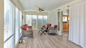 A sunlit room with wicker furniture, a ceiling fan, and a view into the kitchen. - 4 Bed, 1.5 Bath East SLC Apt - Blazing Google Fiber (Salt Lake City)