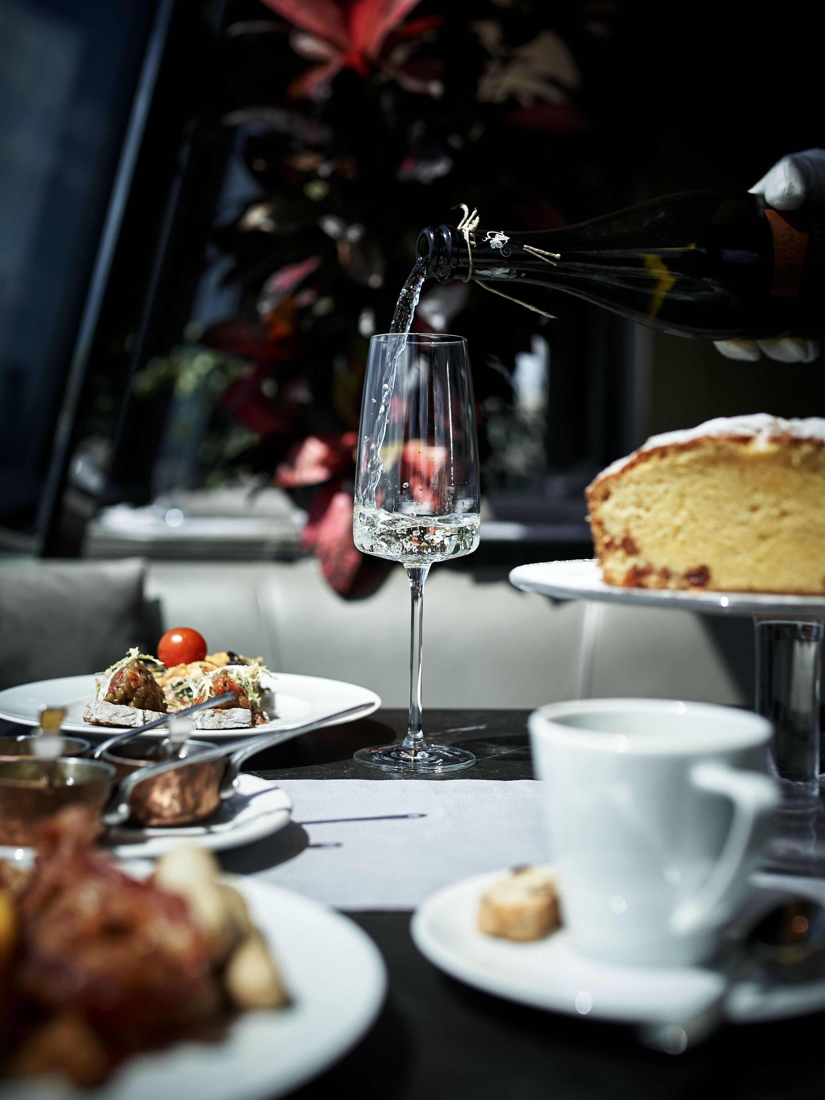 Een tafel met een glas water, gebak en diverse soorten eten.