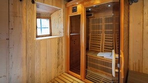Una sauna con paredes de madera y un banco. Cuenta con una ventana y un panel de control.