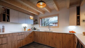 Una cucina moderna con mobili in legno, un'ampia finestra e un lavello integrato.