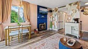 Una sala de estar con chimenea, una mesa de comedor y una estación de café.