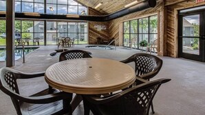 Un espacio interior amplio con una gran mesa y sillas, ventanas grandes y vistas al exterior.