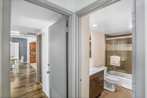 A modern bathroom with a bathtub, toilet, and vanity.