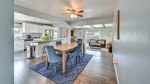A spacious kitchen with a dining area, wooden flooring, and a ceiling fan. - Walkable Chula Vista Home w/ Covered Patio (Chula Vista)