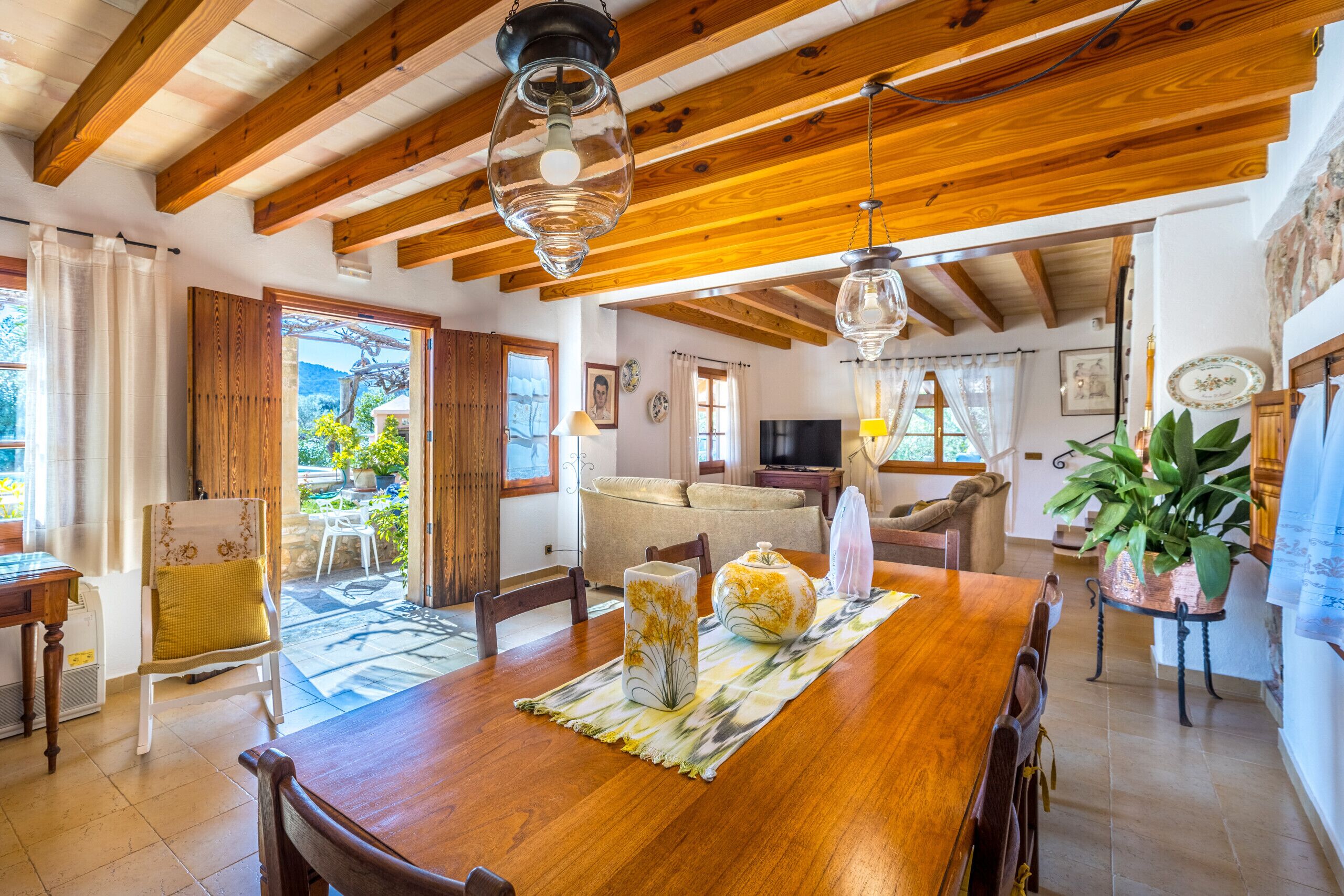 Un comedor amplio con una mesa de madera, sillas y vistas al exterior.