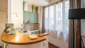 Een keuken met een gebogen aanrecht, een spoelbak en een raam met gordijnen.