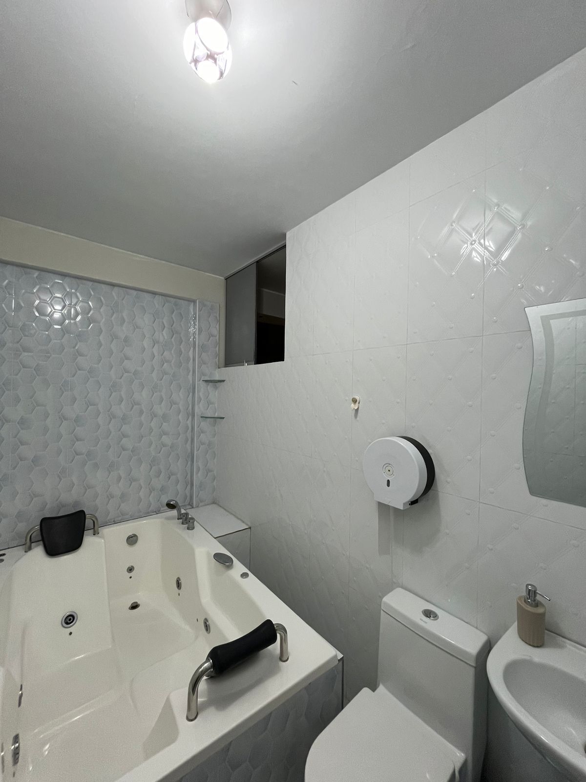 Un baño moderno con una bañera grande, un inodoro y un lavabo.