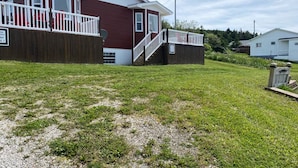Ett tvåvåningshus med en träveranda och en inhägnad trädgård.
