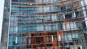 Een modern glazen gebouw met een gebogen gevel en horizontale lijnen.